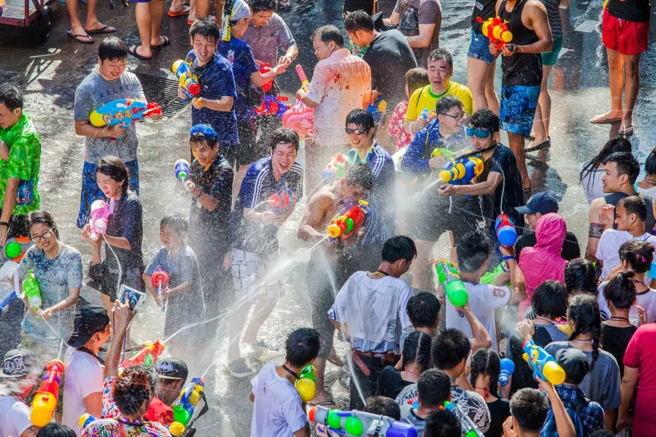 Folk firar Songkran i Thailand med vattenpistoler och glädje.