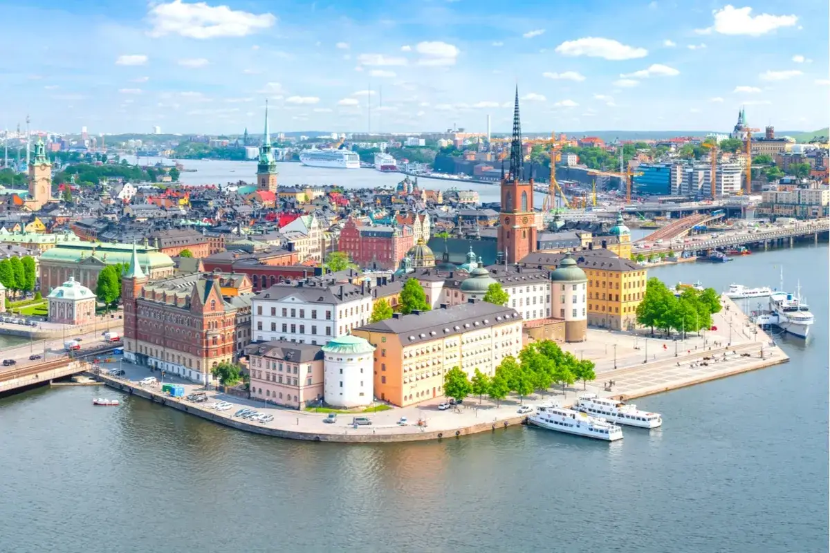 Stockholm, en liten europeisk huvudstad, breder ut sig vid vattnet med sina f&auml;rgglada hus och kyrktorn.