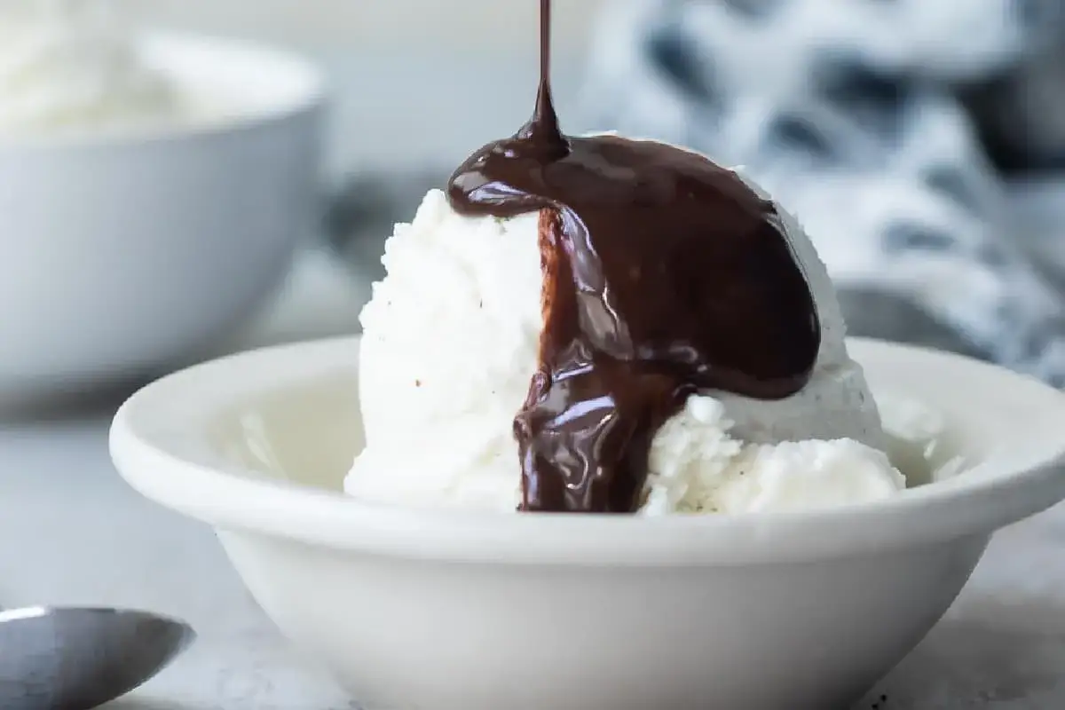 Kr&auml;mig vaniljglass i sk&aring;l, &ouml;verh&auml;lld med varm choklads&aring;s. Ett enkelt choklads&aring;s recept som lyfter desserten.