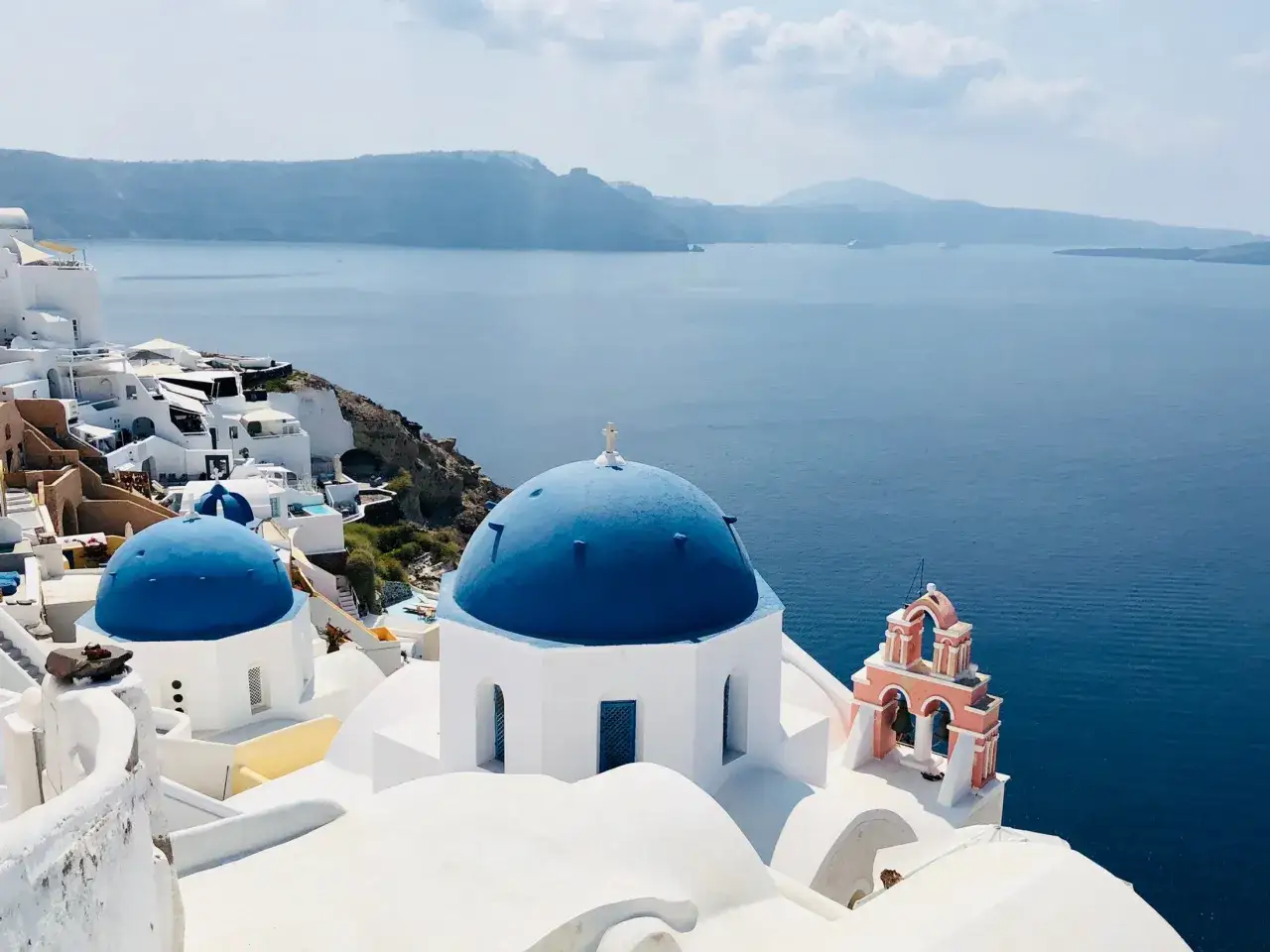 Bl&aring; kupoler och vita hus kantar klipporna vid havet. En dr&ouml;mresa till Santorini.