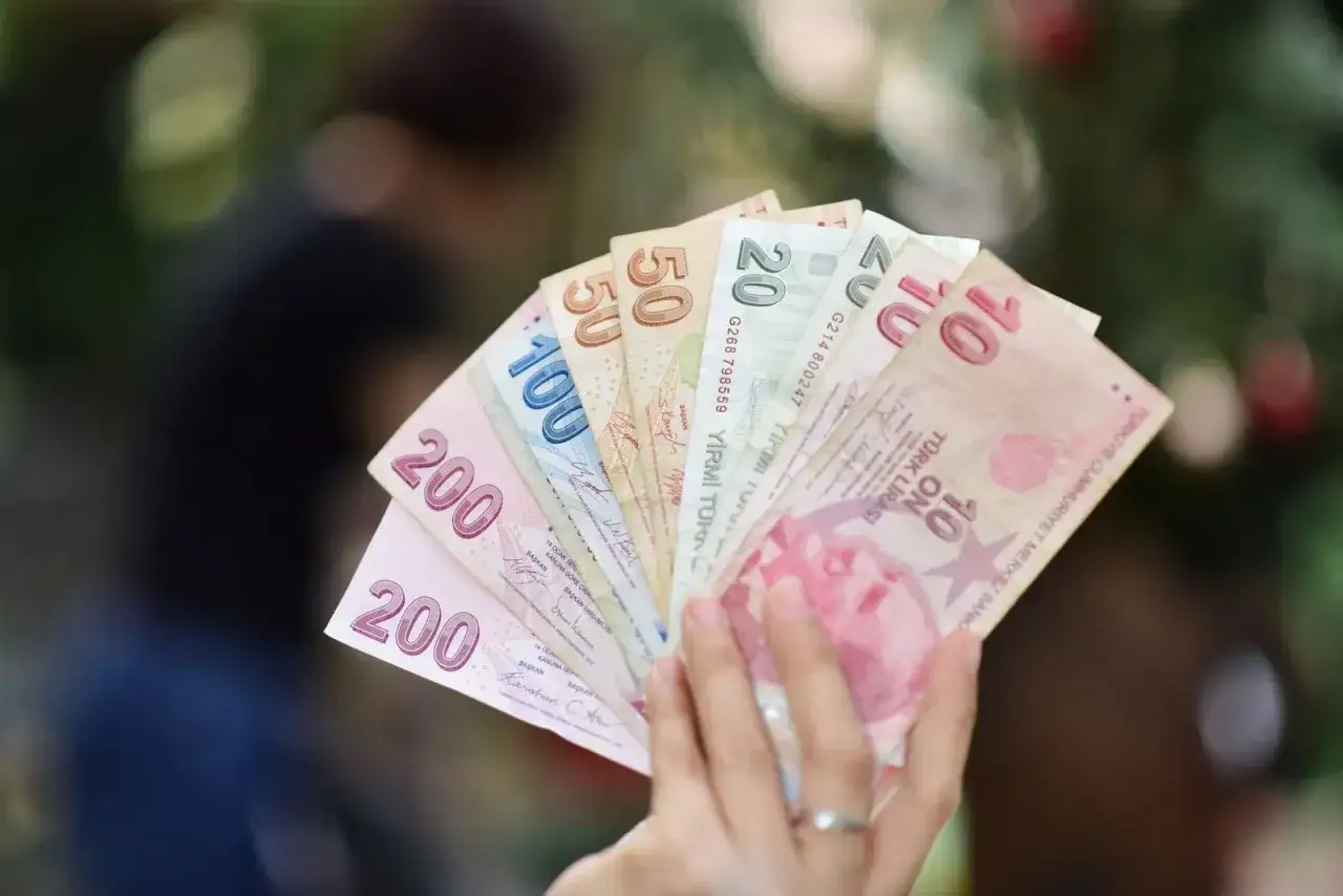 En hand h&aring;ller en solfj&auml;der av turkiska lira-sedlar. Valuta Turkiet.
