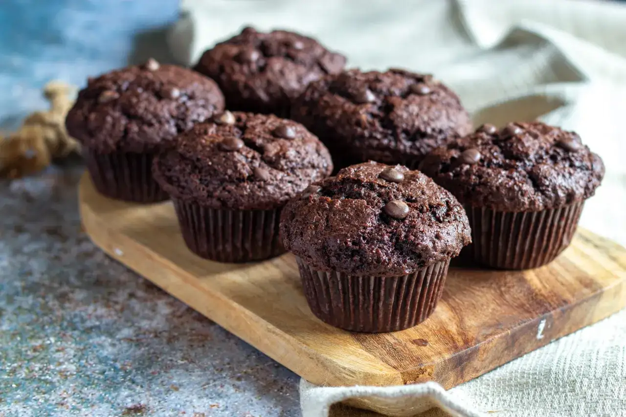 M&ouml;rka, saftiga chokladmuffins med chokladknappar, uppradade p&aring; en tr&auml;bricka. Perfekta f&ouml;r fikat!