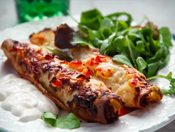 Två gyllene enchiladas med smält ost och en fräsch sallad. Perfekt för ett snabbt enchiladas recept.